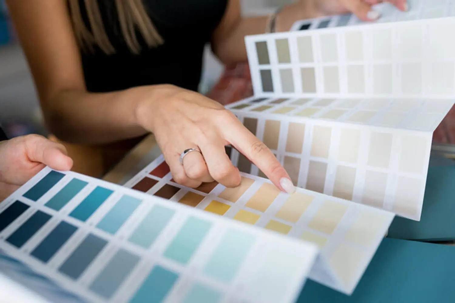 Homeowner reviewing interior paint color swatches with a professional during a color consultation
