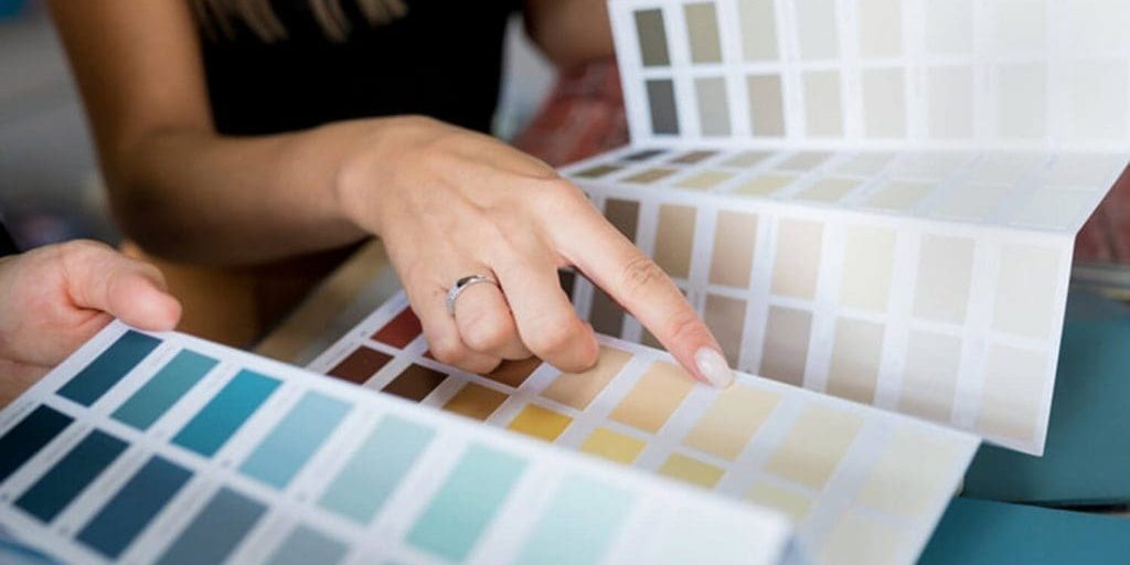 Homeowner reviewing interior paint color swatches with a professional during a color consultation
